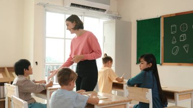 Sınıfta çeşitli çocuklar sınıf ödevlerini yaparken, Kafkasyalı öğretmen sınıfta yürüyor ve öğrenci ödevlerini kontrol ediyor. Çeşitli zeki öğrenciler ilkokulda ders veriyor ve not alıyor. Pedagoji.