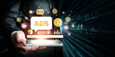 Bir iş adamı canlı online reklam grafikleri gösteren bir akıllı telefon tutuyor. Görüntü, çatışmayı ve görünürlüğü artıran modern pazarlama stratejilerini gösteriyor. XDMCP