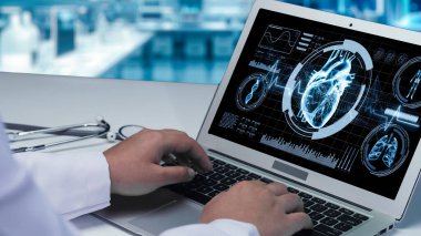 Doktorun bilgisayarda insan kalbi anatomisi olan bilgisayara yazıp baktığı bilgisayarın arka planı bulanık. Sağlık çalışanı kalp ameliyatına hazırlanıyor. İyileştirici.