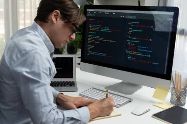 Stresli bilişim geliştiricisi deneme uygulamasında kodlama programı olan bilgisayar ve bilgisayar üzerinde çevrimiçi yazılım geliştirme bilgilerini analiz ediyor. Teknik mühendis önemli not listeleri yazıyor. Bireysel.