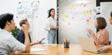 Genç ve güzel lider pazarlama stratejisini sunarken, uzman yatırımcı ve proje yöneticisi de yeni başlayan iş toplantısında iş performansını analiz etmeye çalışıyor. Çok ırklı bir grup. Tertemiz..