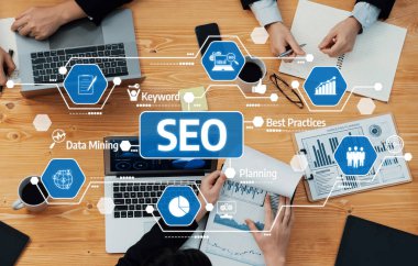 Laptoplar, çizelgeler ve takım etkileşiminin yer aldığı ve veri odaklı karar verme ve planlamayı vurgulayan işbirlikçi bir SEO stratejisinin yer aldığı odaklanmış bir iş toplantısı. Dostluk