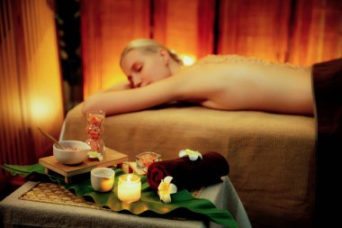 Aromaterapi masajı ambiyansı ya da spa salonu kompozisyon düzeneği bulanık kadınlara odaklı dekor mumları ve spa aksesuarları ile tatil köyü veya otel arka planında keyifli aroma spa masajı yapan. Sessiz.