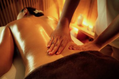 Yakından kadın müşteri strese karşı spa masajını rahatlatıyor ve lüks otel ya da otelde sıcak mum ışığında güzellik teniyle eğleniyor. Sessiz.