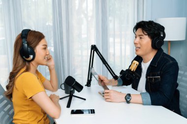 Gülümseyen radyo etkili sunucu elinde tablet, kulaklık takıyor kadın konuşmacı sosyal medya online canlı yayın kanalı ile röportaj yapıyor ve sabah stüdyo kaydında paylaşım linkini paylaşıyor. İnfobahn.