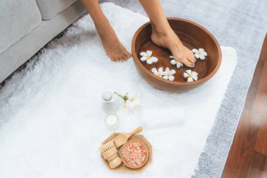 Panorama üstteki kadın lüks spa salonunda mutlu bir ayak masajı yaparken, masör de hafif gündüz atmosfer tesisinde veya otel ayak spasında refleksoloji terapisi uyguluyor. Sessiz.