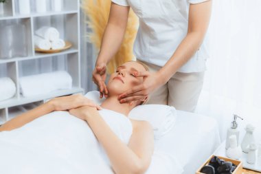 Kafkasyalı kadın stres önleyici kafa masajından ve lüks tatil beldesi ya da otel spa salonundaki modern ışık ortamında yüz güzelliği eğlencelerini şımartmaktan hoşlanıyor. Sessiz.