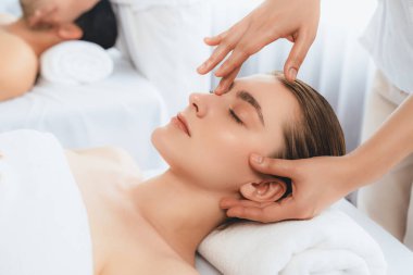 Kafkasyalı çift stres önleyici kafa masajının keyfini çıkarıyor ve lüks otellerde ya da otel spa salonlarında gündüz kaplıcalarında yüz güzelliği eğlencelerini şımartıyor. Sessiz.