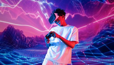 Neon soyut arka planda oyun oynarken elinde joystick tutan ve VR gözlük takan bir genç. Afrikalı adam kontrol etmeyi ve artırılmış gerçeklik teknolojisini kullanmayı seviyor. Yaratıcılık.