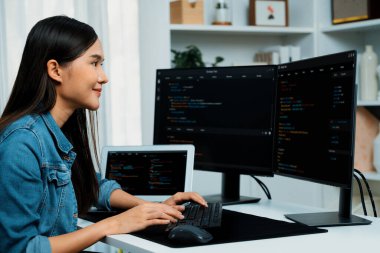 İnternet sitesi uygulamasının kodlama verileriyle birlikte online bilgi yazarak kot gömlek giyen genç Asyalı geliştirici. Güvenlik analizi ile çevrili iki ekran. Taktik.