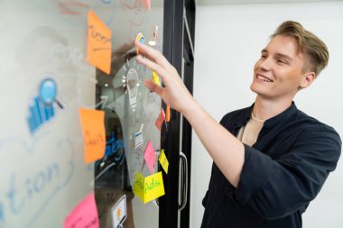 Kafkasyalı profesyonel iş adamının zihin haritası ve renkli yapışkan notlar kullanarak iş pazarlama fikrini kendine güvenle sunuşunun yakın görüntüsü. Proje konseptini başlat. Portre. Tertemiz..