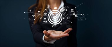 Bir iş kadını, çevrimiçi iş ortamında strateji ve büyümeyi sembolize eden dijital pazarlama unsurlarıyla çevrili bir hedef ikonu sergiliyor. XDMCP