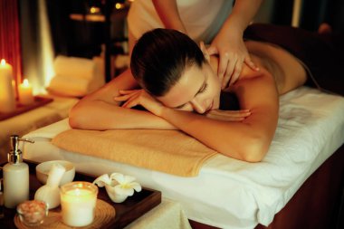 Beyaz kadın müşteri stres önleyici spa masajının keyfini çıkarıyor ve lüks otel ya da otelde sıcak mum ışığında güzellik teniyle eğleniyor. Sessiz.