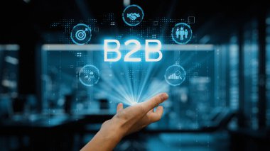 Bu resim, modern bir ofiste, B2B ağ oluşturma, büyüme, bağlantı ve veri analizinin unsurlarını teknoloji odaklı bir dünyada sergilemek için uzanan bir eli tasvir ediyor. Auvana