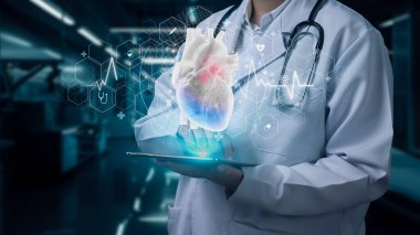Doktorun elinde insan kalbi hologramıyla hastanede bulanık bir geçmişi olan tableti tutmasına yakın çekim. Laboratuvar önlüklü zeki bir tıp çalışanı kalp atışlarıyla insan organlarını kontrol ediyor. İyileştirici.