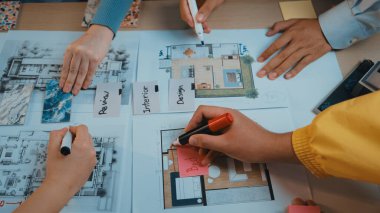 Bir takım, renkli işaretler ve ayrıntılı planlar kullanarak, canlı bir çalışma alanında yaratıcı beyin fırtınası ve stratejik planlama sergileyerek, iç tasarım kavramları üzerinde işbirliği yapar. SACTR