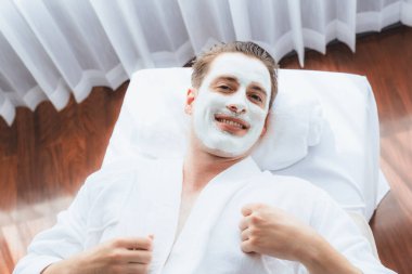 Kaplıca salonunun sakin atmosferi, insan müşterisi modern gün ışığında lüks yüz kremi masajıyla kendini yenileme zevkine kapılıyor. Yüz bakımı ve güzellik konsepti. Sessiz.