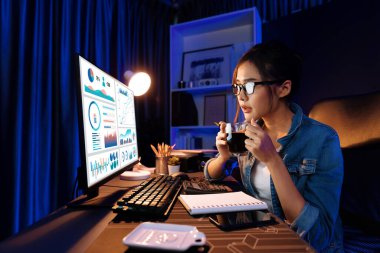 Sunucu kanalı Asyalı etkileyicisi, sosyal medyada kulaklık takarak iş grafikleri ekranında dinleyicileri selamlıyor ve Neon Modern Stüdyoları 'nda internet üzerinden koçluk yapıyor. Taktik.