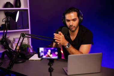 Yayın kuruluşu canlı yayında dinleyiciyle konuşuyor. Mor neon ışık stüdyosundaki yaratıcı pozitif düşünce konseptiyle sosyal medyada akıllı telefonlardan kayıt yapıyor. Tahmin et..