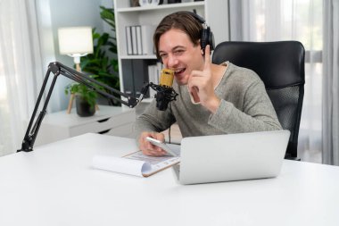 Sunucu kanalı, gülümseyen akıllı yayıncı kaydı, senaryosu ve akıllı telefonuyla sosyal medyada sohbet programı, kulaklık takarak modern ev stüdyosundaki video flamalarını kaydediyor. Bireysel.