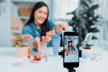 Kozmetik makyaj makyajı, ruj, pastel renkler, sosyal medyada kol testi promosyonunda en çok satan kitaplar koleksiyonunu gösteren seçici odaklı telefon. Taktik.