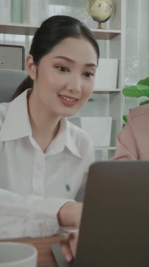 Hevesli ofis çalışanları ofis işyerindeki başarılarını kutluyorlar. Bilgisayarlı bir masada iş birliği yapan ve başarı elde eden meslektaşlar. İki iş kadını işlerinden memnun..