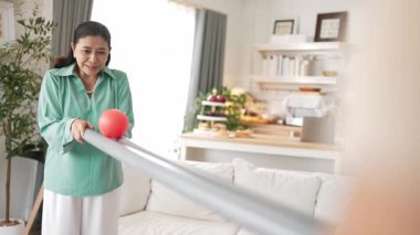 Büyükannenin elinde boru var ve göz, el koordinasyonunu geliştirmek ya da odaklanma ve konsantrasyonu arttırmak için top yuvarlama oyunu oynuyor. Yaşlı çift stresi azaltıyor. Sağlık hizmetleri. Myrmidon.