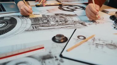 Mühendislerden oluşan dinamik bir ekip, yenilikçi fikirleri hayata geçirmek için çeşitli araçlar kullanarak modern bir çalışma alanında teknik çizimler ve tasarım planları üzerinde işbirliği yapmaktadır. SACTR