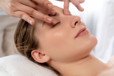 Kafkasyalı kadın stres önleyici kafa masajından ve lüks tatil beldesi ya da otel spa salonundaki modern ışık ortamında yüz güzelliği eğlencelerini şımartmaktan hoşlanıyor. Sessiz.