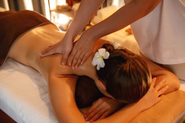 Beyaz kadın müşteri stres önleyici spa masajının keyfini çıkarıyor ve lüks otel ya da otelde sıcak mum ışığında güzellik teniyle eğleniyor. Sessiz.