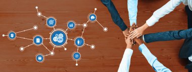 Çeşitli ellerin yukarıdan aşağı bir görünümü, iş büyümesi ve performansı için gösterilen KPI metrikleriyle takım çalışmasını ve işbirliğini sembolize eden ahşap bir masa üzerinde birleşti. Dostluk