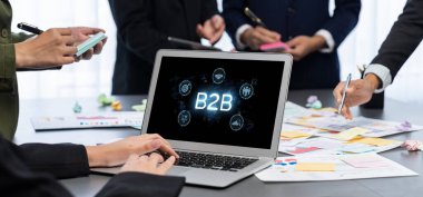 İş adamı B2B peyzajında geziniyor, iş-iş bağlantılarını geliştirmek için kullanım teknolojisi kullanıyor. B2B etkileşimini yeniden şekillendiren keşifler, iş-iş stratejilerinde yenilikleri yönlendiren araçlar. canlı