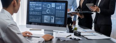 İş zekası ve veri analizi kavramı. Analizci ekibi laptop ekranında finansal veri analizi üzerinde çalışıyor. Etkili iş stratejik planlama için pazarlama göstergesi olarak. İçgörü