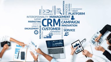 CRM stratejilerini tartışan bir iş toplantısının tepeden tırnağa görüntüsü. Profesyoneller dizüstü bilgisayarlardaki veri ve çizelgeleri analiz ediyor, müşteri ilişkileri ve pazarlama etkinliğini vurguluyor. Dostluk