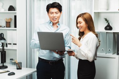 Gülümseyen Asyalı iş arkadaşları modern ofiste dizüstü bilgisayar pazarlama projesi hakkında konuşurken. Yeni sosyal medya kanalında başarılı müşteri ihtiyaçları analiz ediliyor. İnfobahn.