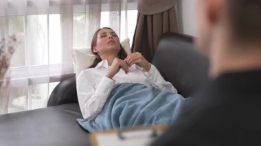 Çömelmiş yatmakta olan genç bir kadın hasta ofiste zihinsel tedavi sırasında travmatik bir olay, endişe ve akıl hastalığından psikiyatriste duygu salıyor. Psikolojik danışma seansı. Düzenle