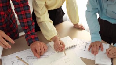 Mimarlık ve güvenlik mühendisi, modern ofiste doğruluk için mimari belge ve ölçüm aracı kullanılarak dizüstü bilgisayarın üzerinde sergilenen planlar hakkında tartıştı. - Yakın çekim. Tanımlama.
