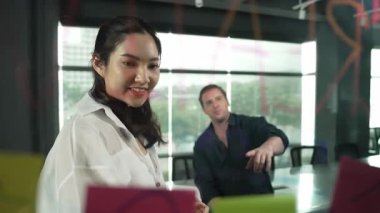 Genç kendine güvenen iş kadını projeyi uzman yatırımcıya sundu. Profesyonel proje yöneticisi başlangıç projesini açıklamak için yapışkan notlar kullanır, beyin fırtınası fikirlerini yatırımcıya paylaşır. Yönlendirici.