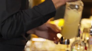 Yakınlaştırma, barmen elinde jigger tutarak şeker tuzunu ölçerek bardaki tüm malzemeleri karıştırma hazırlığı yapıyor. Gece hayatı karışımının sergilendiği özel bir içecek sıcak ışığı davet ediyor. Vinosity.