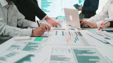 Dinamik bir iş ekibi modern bir ofiste veri analizi ve strateji planlaması yapıyor. Kavrayışları tartışıyor, grafikleri sunuyor ve teknolojiyle etkin bir şekilde işbirliği yapıyorlar. SACTR