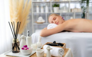 Aromaterapi masajı gündüz atmosferinde ya da spa salonunda bulanık bir kadına odak dekor ve spa aksesuarları kurarak tatil köyünde ya da otel arka planında keyifli aroma spa masajı yapan bir masaj. Sessiz.