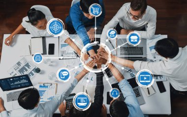 Üst düzey ofis çalışanları ofis odasında el ele tutuşarak iş sinerjisini ve iş yerindeki güçlü üretken takım çalışmasını sembolize ediyor. İş çalışanları arasındaki işbirliği ve birlik. İhtiyatlı Dostluk