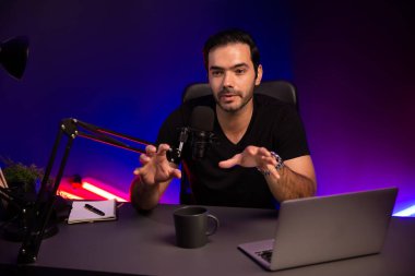 Yayıncı, fanclub dinleyicisiyle mikrofon kullanarak konuşuyor. Mor neon ışıklı modern stüdyoda yaratıcı olumlu düşünce konseptiyle canlı yayında finansal sorunları tartışıyor. Tahmin et..