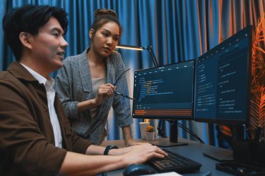 Bilgi teknolojisi geliştiricileri modern ofisteki neon ışık odasında verileri çevrimiçi olarak çalıştıran akıllı web sitesi geliştirme kodlayıcı sistemine işaret ediyorlar. İnfobahn.