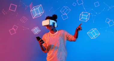VR gözlüklü Afrikalı kız mavi ve pembe arka planda duruyor ve yüzen geometrik şekle bakıyor. Heyecanlı insan görsel gerçeklik dünyasına giriyor. Teknoloji yeniliği. Yaratıcılık.