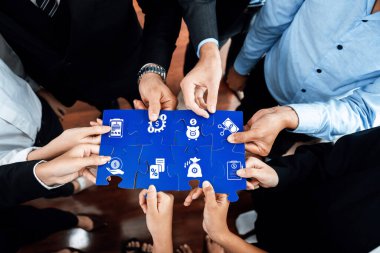 Yapboz parçalarını ikonlarla birleştirmek, iş stratejilerini ve modern ofis ortamındaki yenilikçi çözümleri sembolize etmek için işbirliği içinde çalışan çeşitli profesyonellerden oluşan bir grup. Dostluk