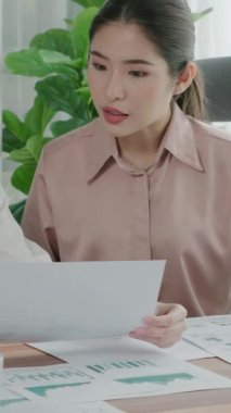 Ofis çalışma alanında birlikte çalışan iki genç hevesli iş kadını. Genç meslektaşlar tartışırken ve dizüstü bilgisayar kullanırken. Modern ofis çalışanları masada birlikte oturuyorlar..