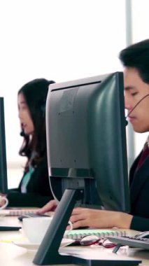 Ofiste çalışan kulaklık takan işadamları uzak müşteri ya da meslektaşlarını desteklemek için çalışıyorlar. Arama merkezi, tele pazarlama, müşteri destek acentesi telefon görüşmesinde hizmet sunar.