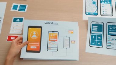 Mobil uygulama için kullanıcı arayüzü prototipi ya da masadaki program modeliyle birlikte web sitesi planlaması yapan bir şirket çalışanı. UX UI tasarımcısı kullanıcı dostu arayüz planını dikkate alır. Sinerjik