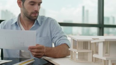 Ev modelini ölçerken ve gökdelen ile not alırken profesyonel mühendis projeye bakıyor. Yetenekli mimar mühendisi planlama, cetvel kullanarak mimari model tasarlama. İzleme